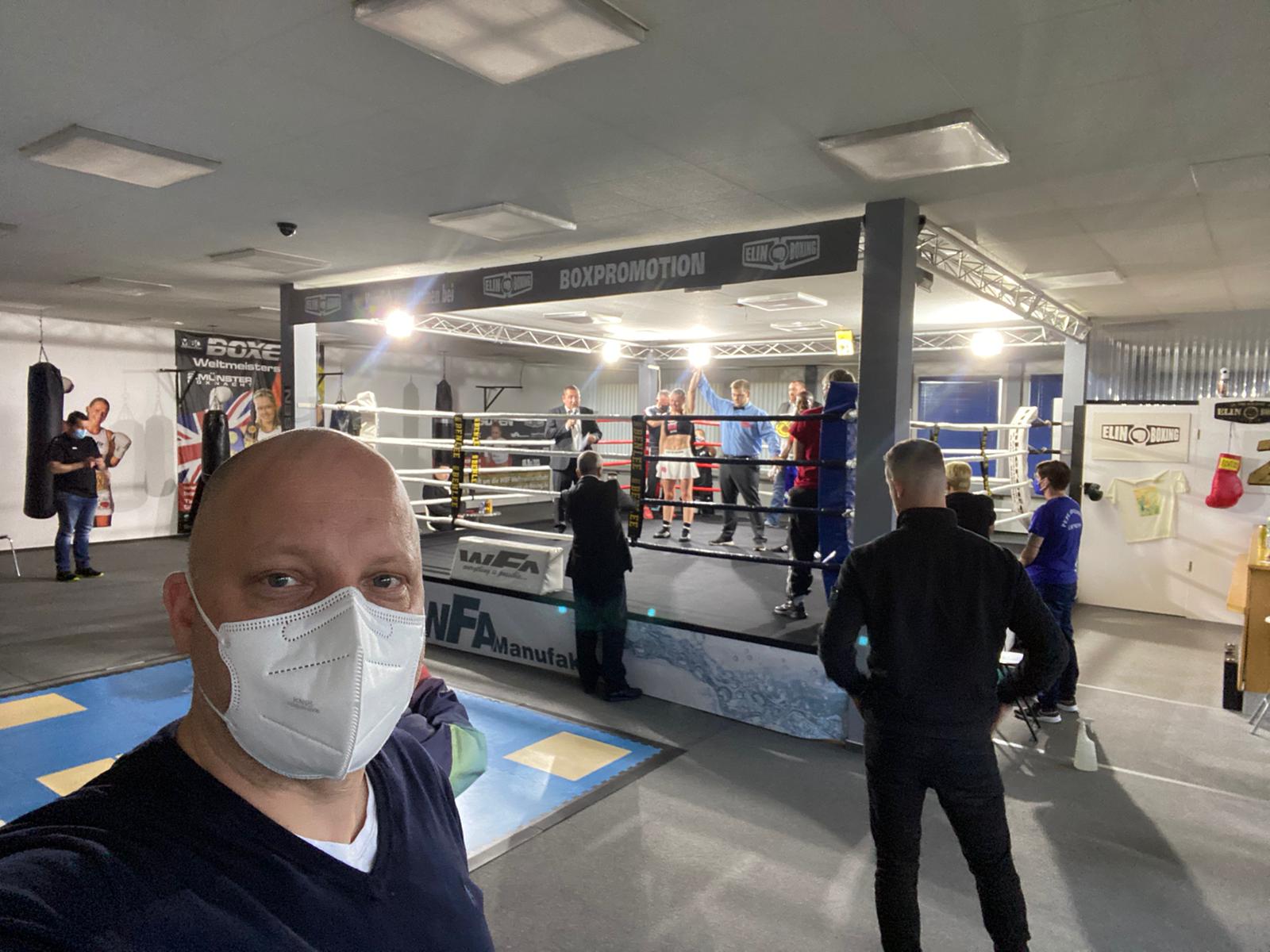 Dr. Timm Schmidt-Mertens vor dem Ring, während Elina Tissen um die Weltmeisterschaft boxt